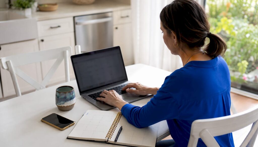 Small business owner scheduling appointments on laptop