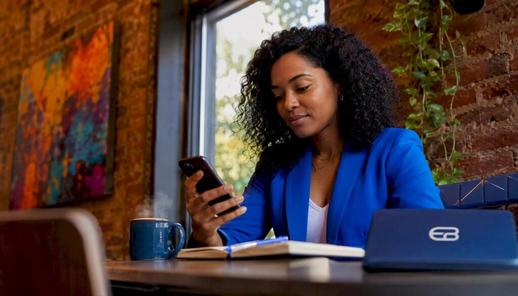 Woman using spa booking app on smartphone in home office
