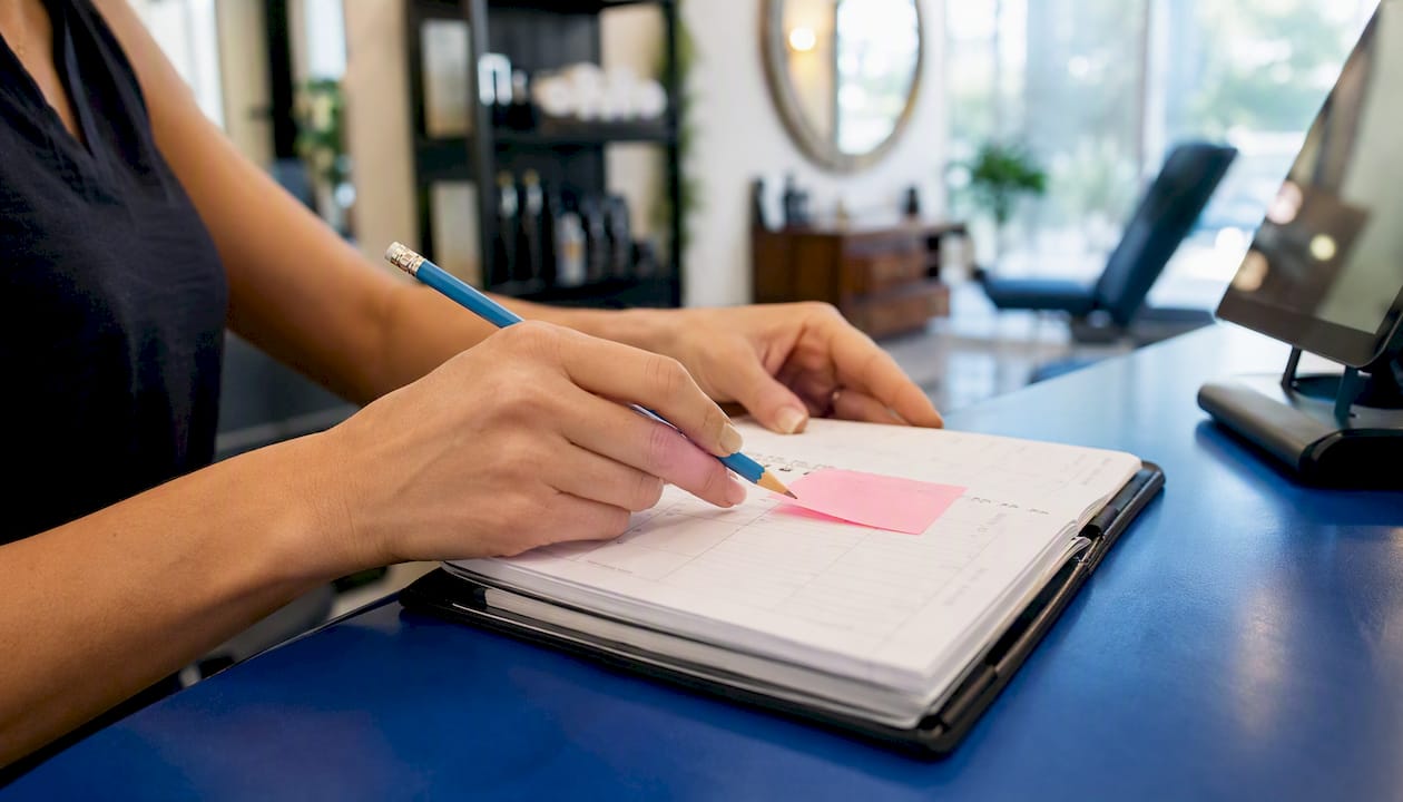 Hands adjusting appointment on wall calendar