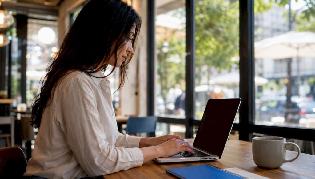 Hands typing reschedule email on laptop
