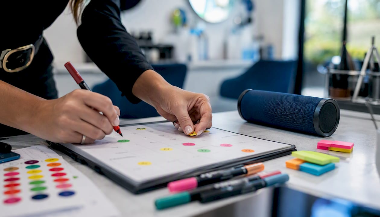 Hands placing recurring event markers on calendar