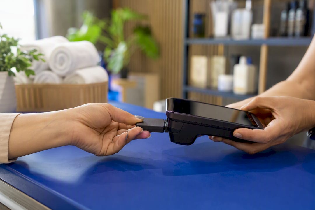 Hands inserting tokenized payment device in terminal